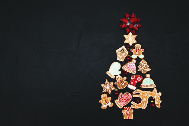 Christmas tree made from gingerbread and spices on a dark background. Copy space. New Year and Christmas greeting card.