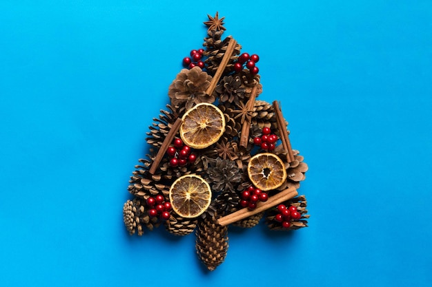 Christmas tree made from natural cones on colored background view from above New Year minimal concept with copy space