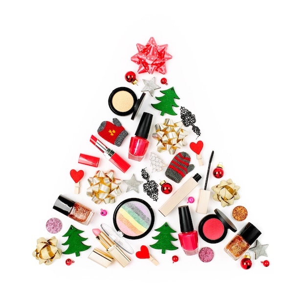 Christmas tree made from winter decorations and cosmetic products on white background. Holiday and celebration creative concept. Flat lay, top view