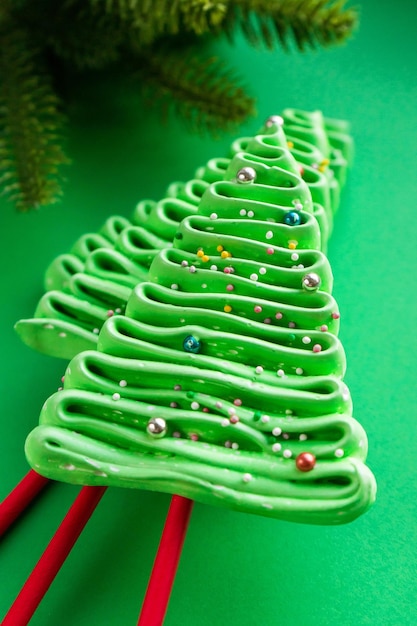 Christmas tree made of meringues in New Year's style on a green background.