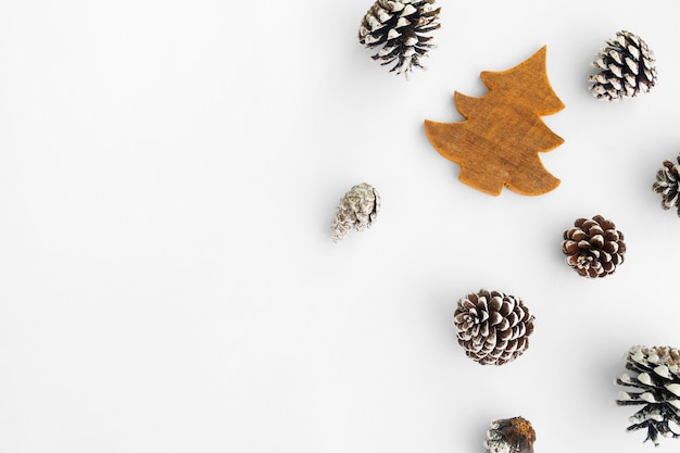 Christmas tree and pine cones on white paper, border composition. 