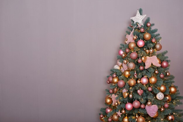 Christmas tree in pink loft style interior.  Christmas tree on gray background