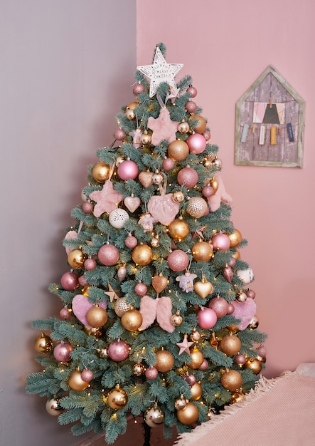 Christmas tree in pink loft style interior.  Christmas tree in winter interior bedroom