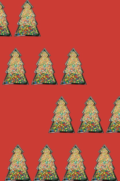 Christmas tree shaped frame filled with many colorful candy sprinkles on red background with copy space Creative New Year wallpaper pattern idea Flat lay lay out party theme