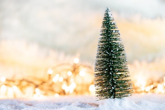 Christmas tree on snow with gift and light bokeh backgrounds 