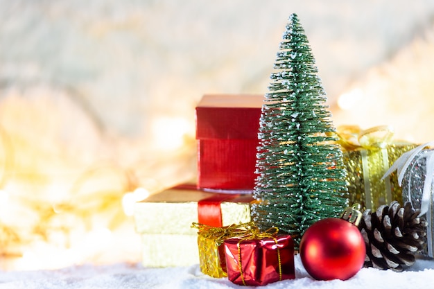 Christmas tree on snow with gift and light bokeh backgrounds