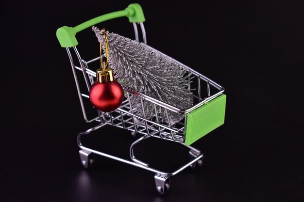 Christmas tree in a supermarket trolley on a black background