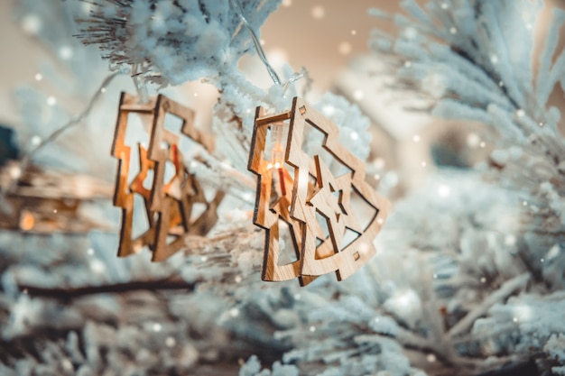 Photo christmas tree toys decorations and snow-covered christmas tree branches close-up with snowfall, falling snowflakes, spots white color. winter christmas new year background.