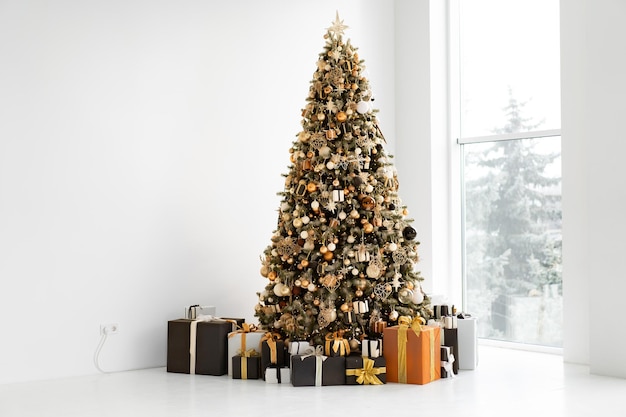 Christmas tree in white interior with stylish black and orange gift box