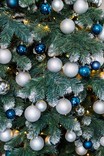 Christmas tree with blue and silver toys Festively decorated Christmas tree with garlands Symbol of the new year