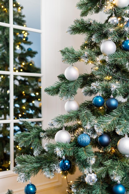 Christmas tree with blue and silver toys Festively decorated Christmas tree with garlands Symbol of the new year