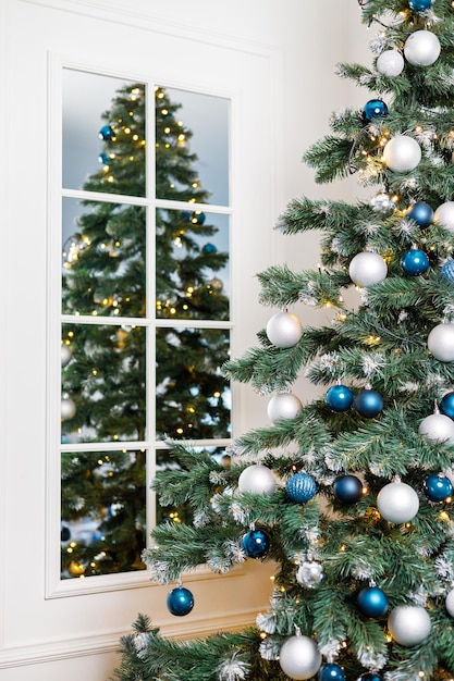 Christmas tree with blue and silver toys Festively decorated Christmas tree with garlands Symbol of the new year