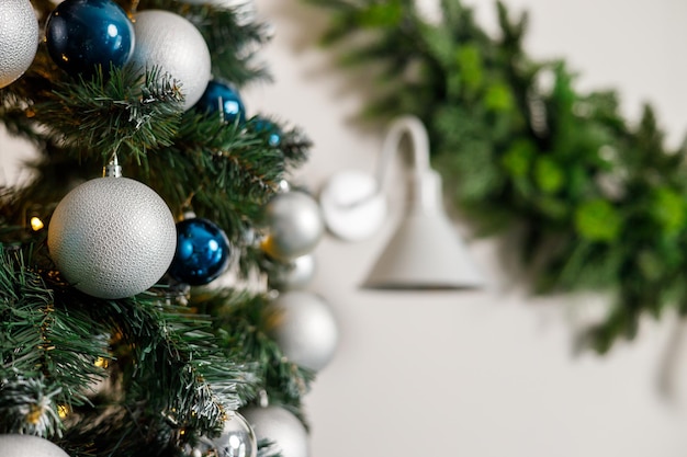 Christmas tree with blue and silver toys Festively decorated Christmas tree with garlands Symbol of the new year