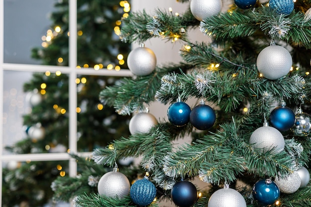 Christmas tree with blue and silver toys Festively decorated Christmas tree with garlands Symbol of the new year