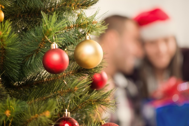 Christmas Tree with Christmas Decoration. Focus On Foreground. Background is Happy Christmas couple.