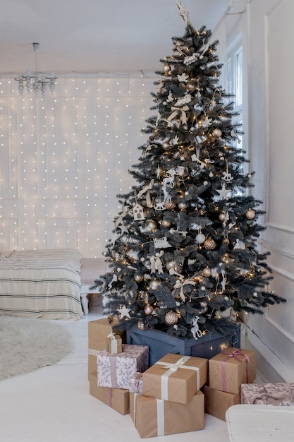 Christmas tree with colorful balls and gift boxes in the room 