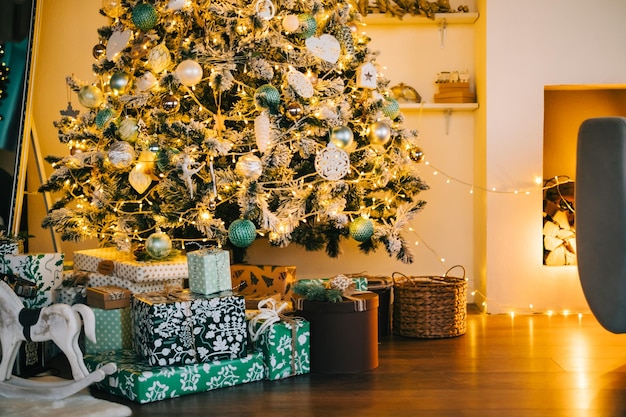 Christmas tree with gifts in living roomin in the evening.