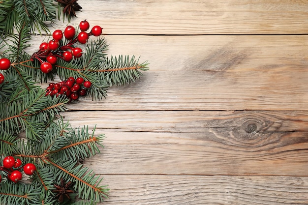 Christmas tree with red berries on a wooden background