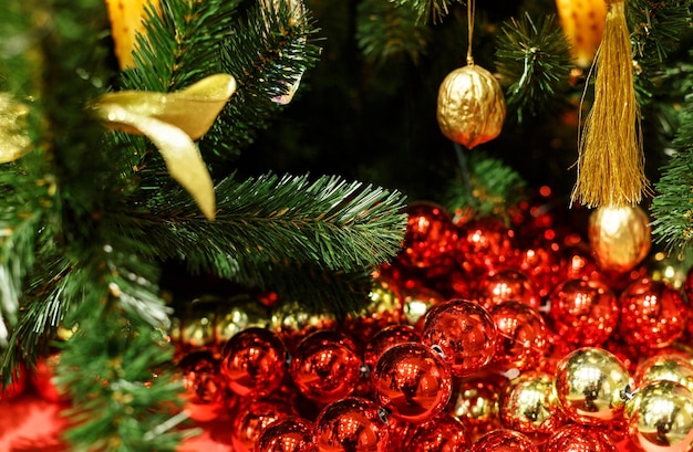 Christmas tree with red toys. Concept New Year celebration background. Closeup photo of christmas tree decorated with red toys