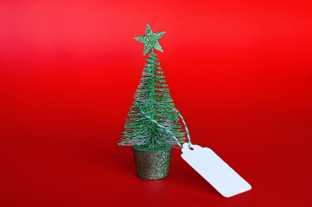 Christmas tree with a tag on a red background the concept of Christmas sales and discounts