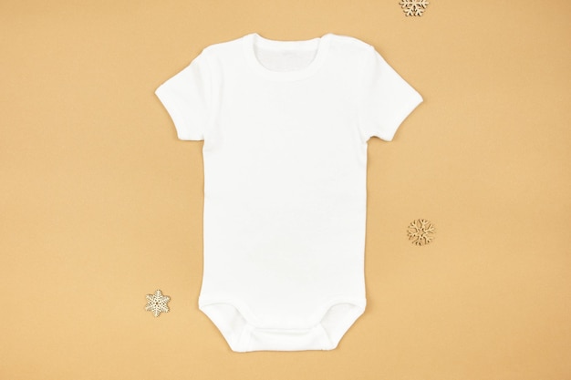 Christmas white baby girl or boy bodysuit mockup flat lay with snowflakes decoration on paper background Design onesie template print presentation mock up Top view