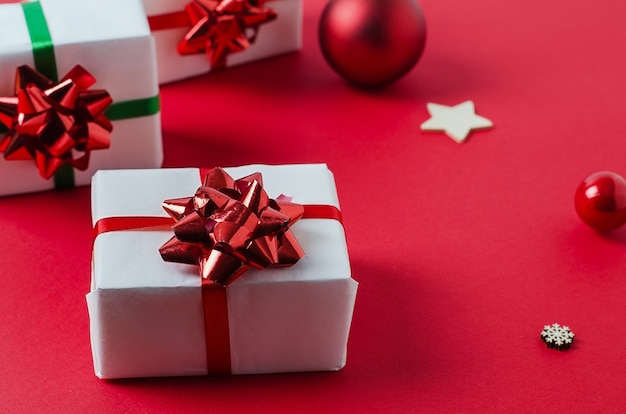 Christmas white handmade gift boxes on a red background tied with a red ribbon. Merry christmas