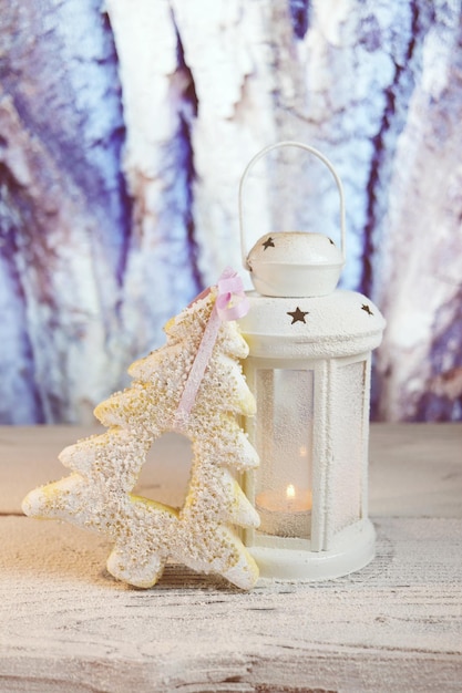 Christmas, white lantern with a burning candle, on a wooden table, Christmas decorations