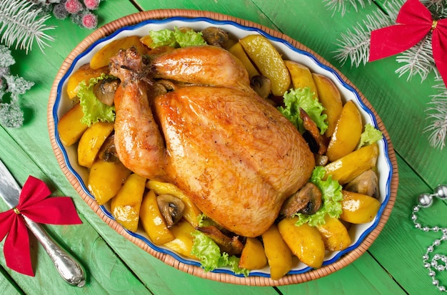 Christmas whole roasted chicken stuffed with mushrooms and baked with potatoes and mushrooms