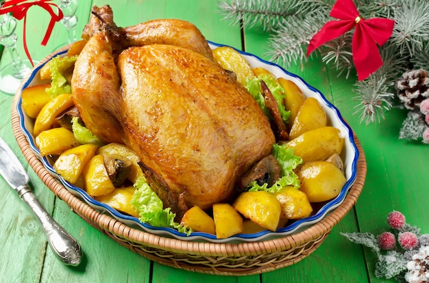 Christmas whole roasted chicken stuffed with mushrooms and baked with potatoes and mushrooms