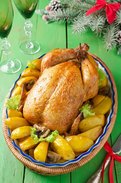 Christmas whole roasted chicken stuffed with mushrooms and baked with potatoes and mushrooms