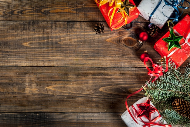 Christmas wooden background with Christmas gifts, fir tree branches and decorations. Copy space