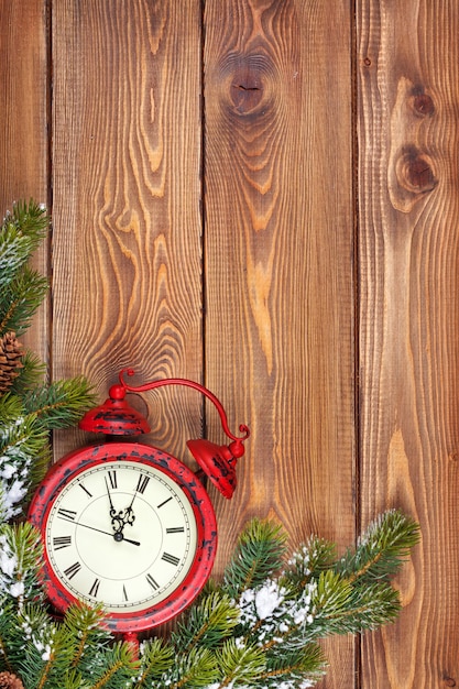 Christmas wooden background with clock snow fir tree