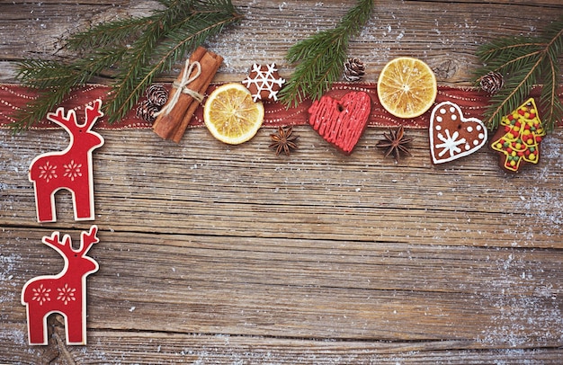 Christmas wooden background with homemade christmas cookies deer cinnamon and christmas tree toned