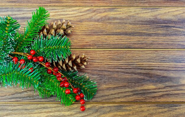 Christmas wooden background with snow fir tree holly berry