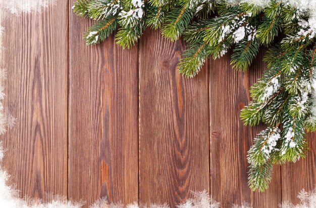 Christmas wooden background with snow fir tree