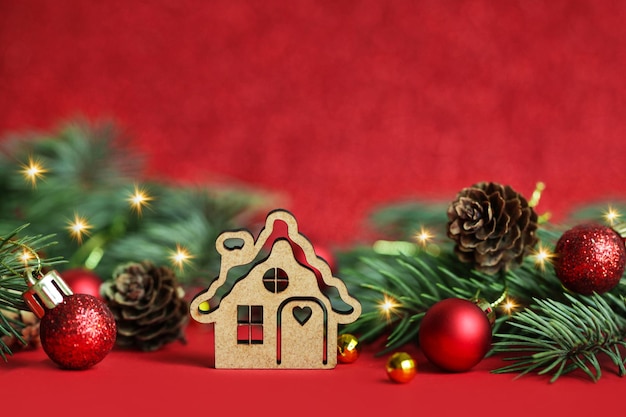 Christmas wooden toy house on red christmas background Concept staying at home Space for text