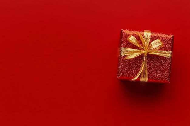 Photo christmas wrapped gift with stars on red background