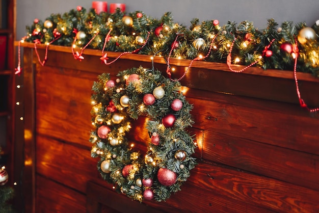 Christmas Wreath Hangs Closeup on Wooden Fireplace Redgold New Year Decoration of House