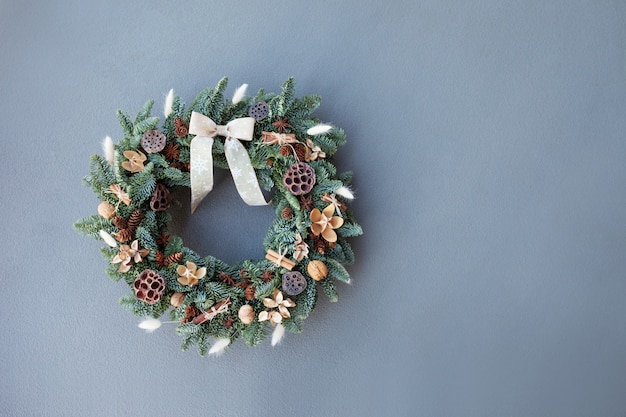 Christmas wreath made of natural fir branches  hanging on a grey wall