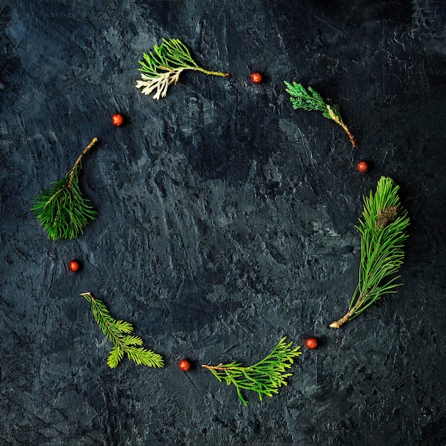 Christmas wreath made of various pine branches on a dark concrete background Christmas layout