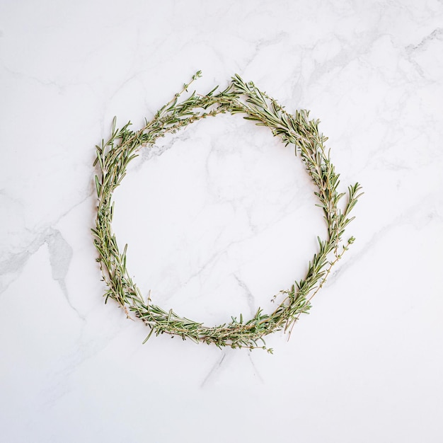 Christmas wreath of rosemary thyme on a white marble surface