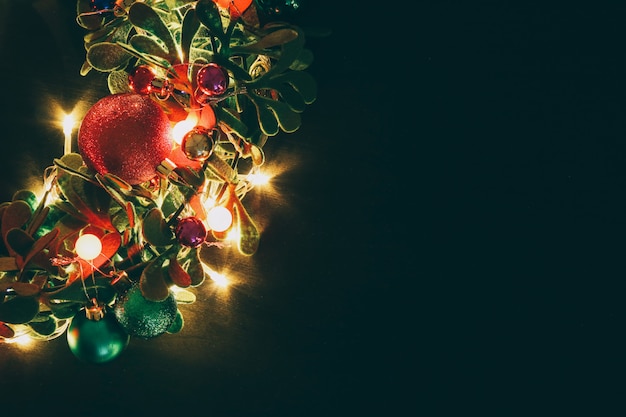 Christmas wreath with decorative light on dark wood background