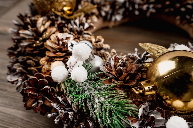 Christmas wreath with festive decor and Christmas tree toys on a wooden background