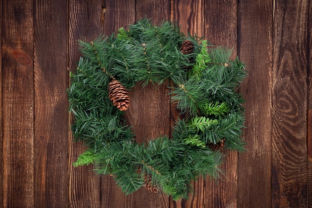 Christmas wreath on wooden background. Mock up. Greeting card.