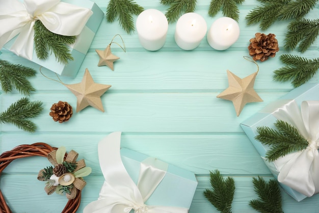 Christmas wreaths, coniferous branches, gifts, toys, cones are on the table. View from above.