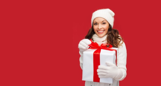 christmas, x-mas, winter, happiness concept - smiling woman in white clothes with gift box