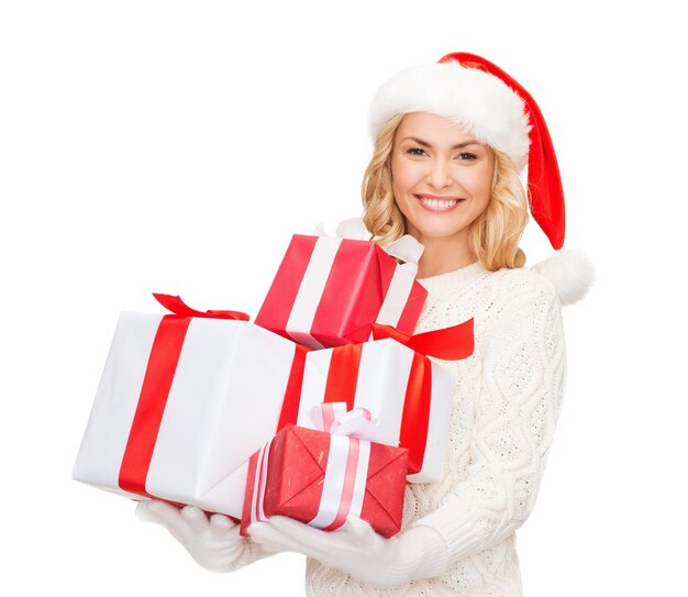 christmas, xmas, winter, happiness concept - smiling woman in santa helper hat with many gift boxes