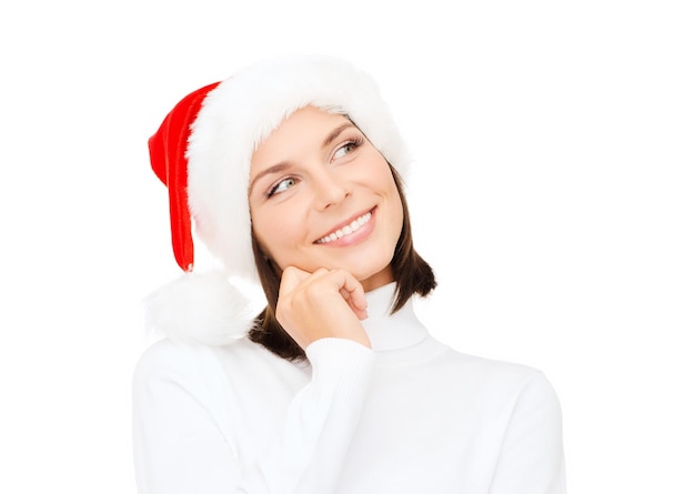 christmas, xmas, winter, happiness concept - thinking and smiling woman in santa helper hat