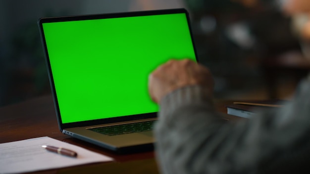 Chroma key computer closeup Unknown old man having video call at green screen laptop at home Unrecognizable senior man talking online at mockup computer Male person having online conference at home