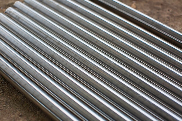 Chrome stainless pipes background in a stack waiting for shipment in the warehouse